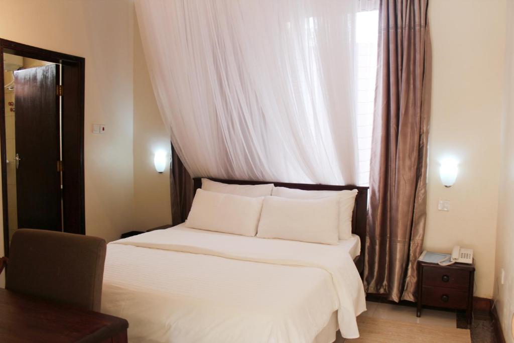 金贾阿尔尼莎Spa酒店的一间卧室配有一张带白色床单的床和一扇窗户。