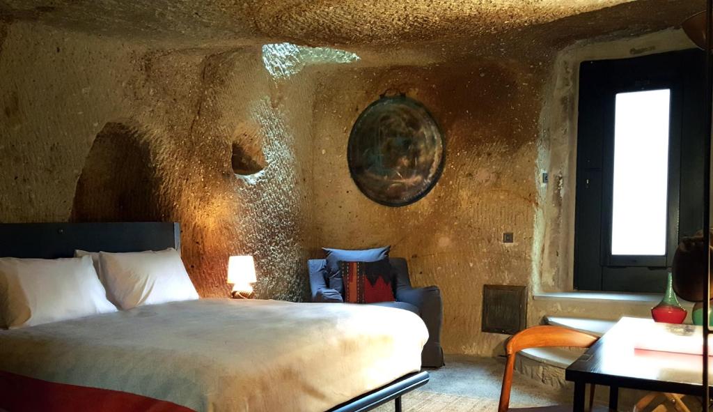 于尔居普索塔卡帕多西亚旅馆的一间卧室配有一张床、一张沙发和一个窗口