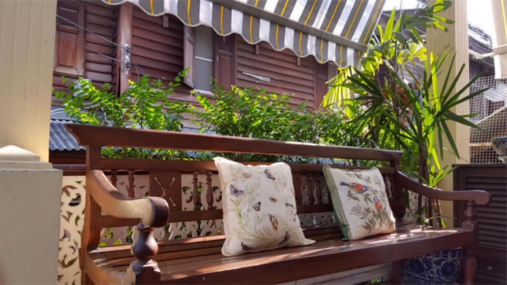 曼谷曼考拉别墅旅馆的一张木凳,上面有两个枕头