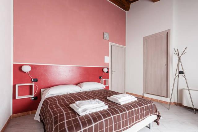 比萨比安奇64号住宿加早餐旅馆的一间卧室设有一张红色墙壁的大床