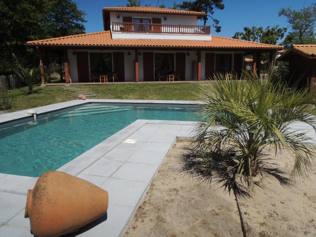 比斯卡罗斯Via Bahia - Maison d'hôtes的房屋前有游泳池的房子