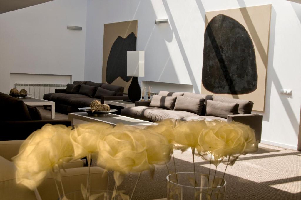 阿蒂恩萨Hospedium Hotel Convento de Santa Ana的客厅配有沙发和鲜花桌
