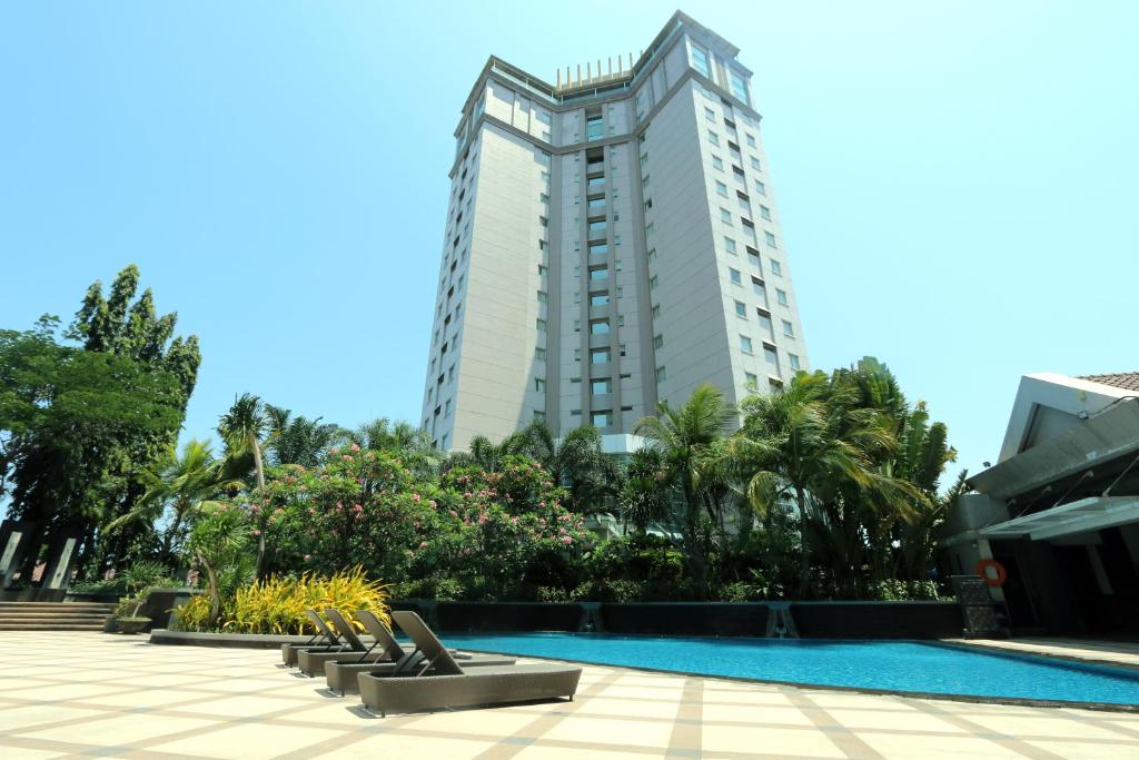 泗水爪哇岛百诺肯酒店的一座带游泳池和高楼的酒店