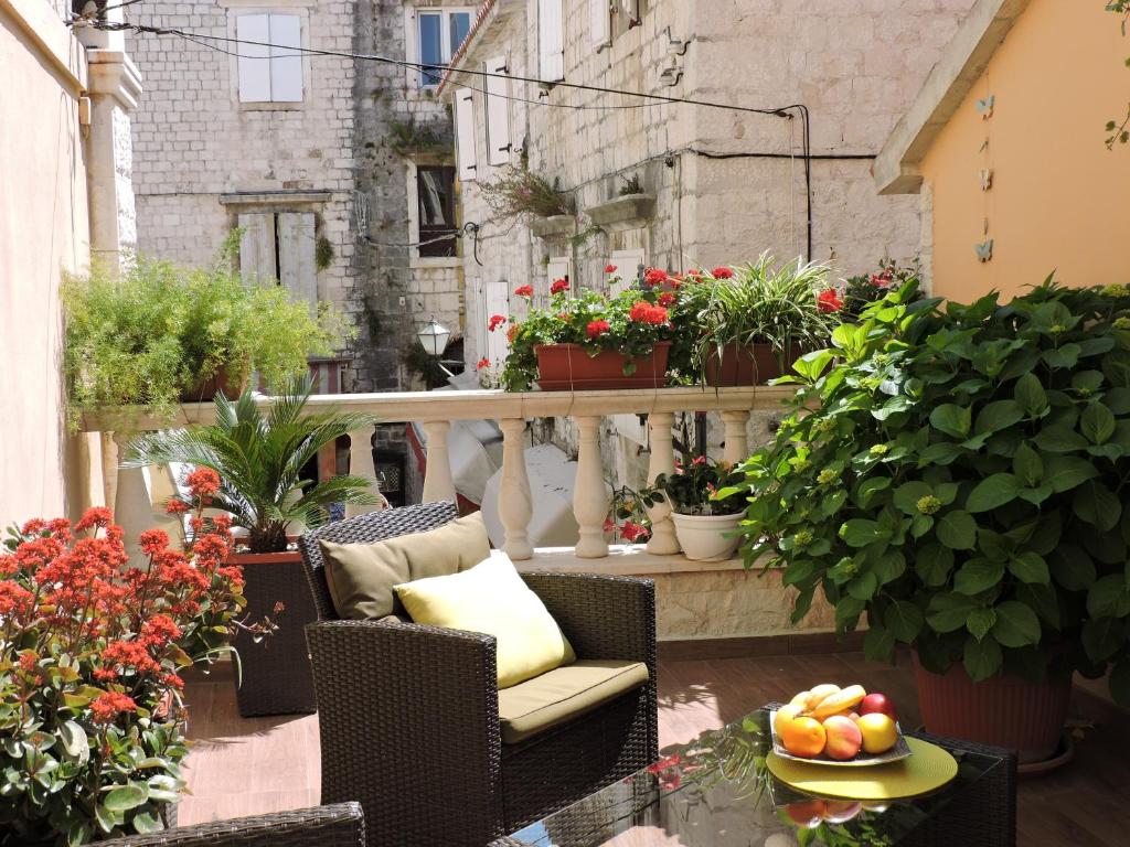 特罗吉尔Apartments & Rooms Trogir Stars FREE PARKING的阳台种有植物,桌子上放着一碗水果