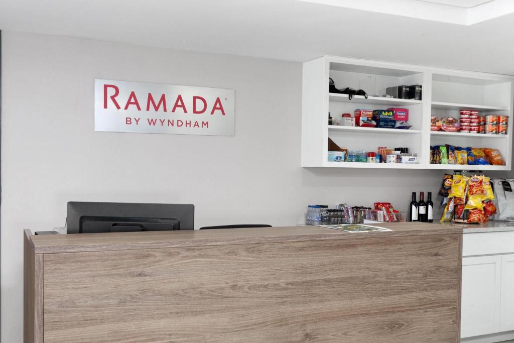 密尔沃基Ramada by Wyndham Milwaukee的柜台上方的招牌上写着“Ramada by Vitimarian”