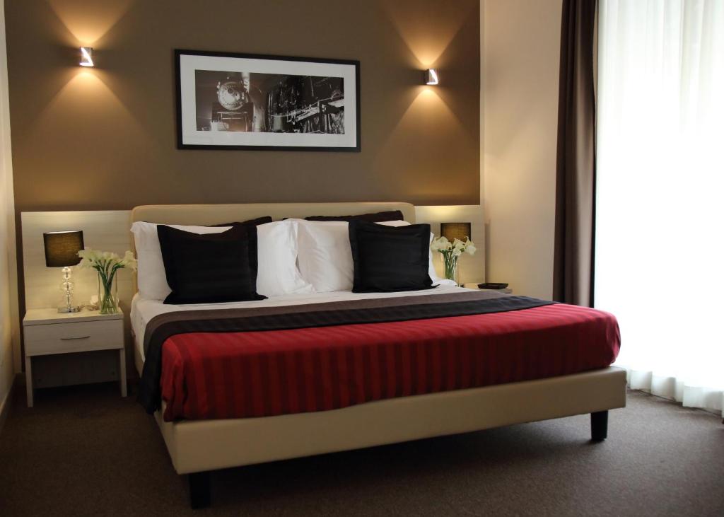 那不勒斯布斯内斯特斯特尔酒店的一间卧室配有一张带红色毯子的大床