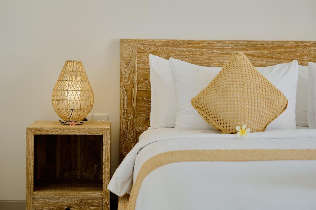 乌布Luxury Nanda villa Ubud的一张带木制床头板和台灯的床