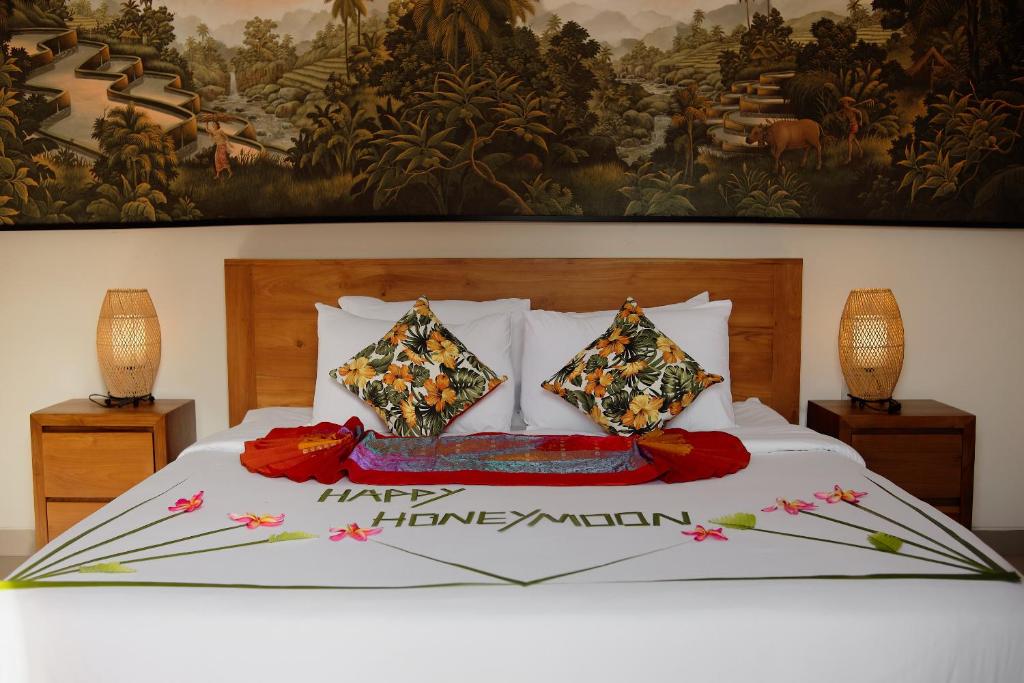 乌布Luxury Nanda villa Ubud的卧室里有一张白色的大床，墙上挂着一幅画
