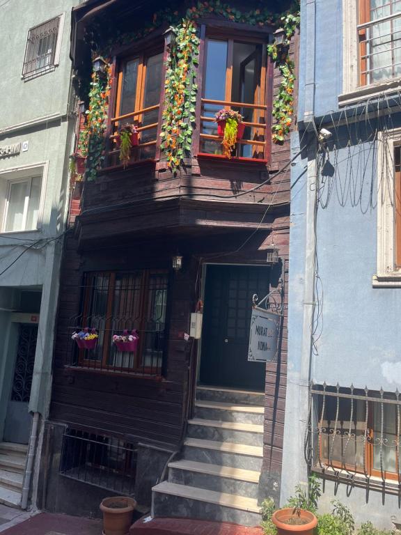 伊斯坦布尔Murat bey konağı的一栋有楼梯和窗户的建筑，上面有鲜花
