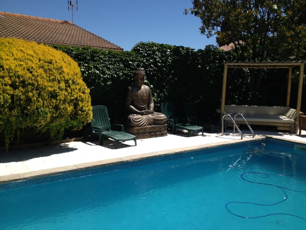 MudaisonVilla ou studio indépendant PISCINE sans vis à vis的一座雕像,毗邻一座带雕像的游泳池
