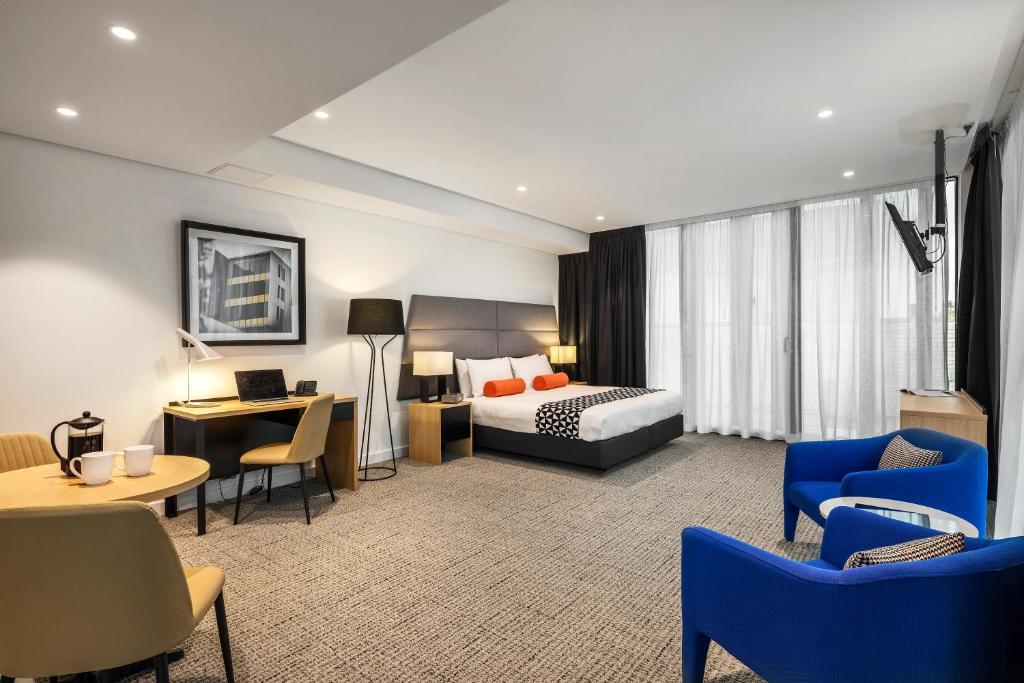 悉尼圣伦纳兹探索公寓的酒店客房,配有一张床、一张桌子和椅子
