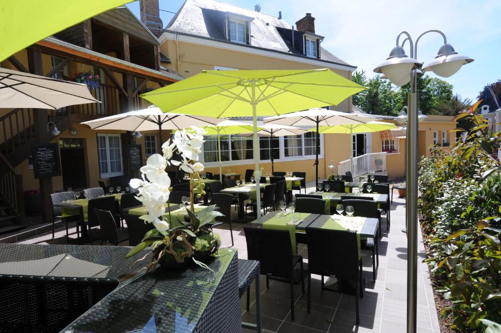 Thorigné-sur-DuéHôtel Saint Jacques的一间带桌椅和遮阳伞的餐厅