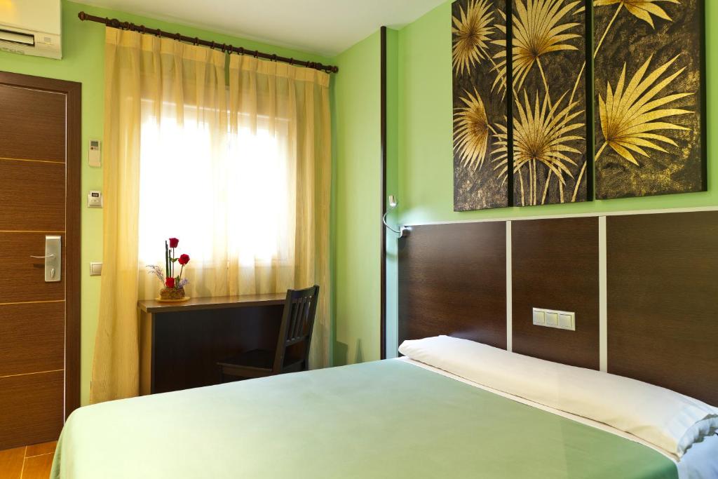 马德里阿维尼达巴拉哈斯酒店的一间卧室设有一张大床和一个窗户。