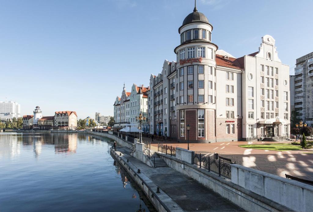 加里宁格勒Kaiserhof Hotel的一座在河边设有钟楼