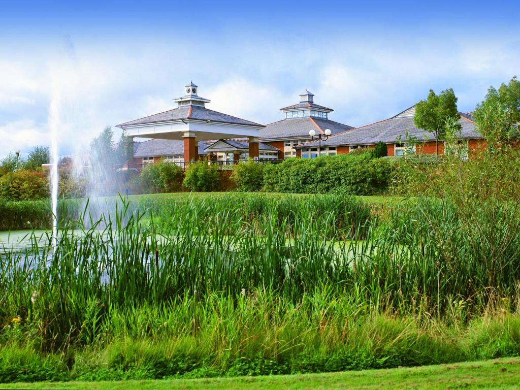 布罗姆斯格罗夫布罗姆斯格罗夫Spa酒店的池塘中央有喷泉的建筑物