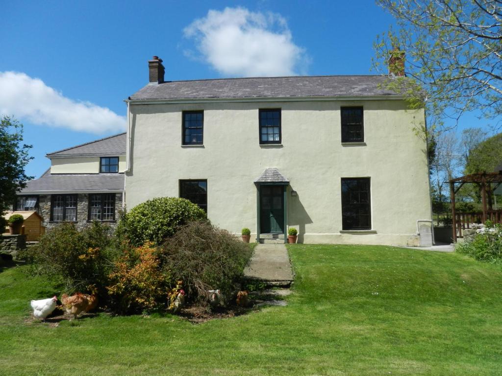 AbernantCilwen Country House Bed and Breakfast的一间大型白色房屋,设有黑色窗户