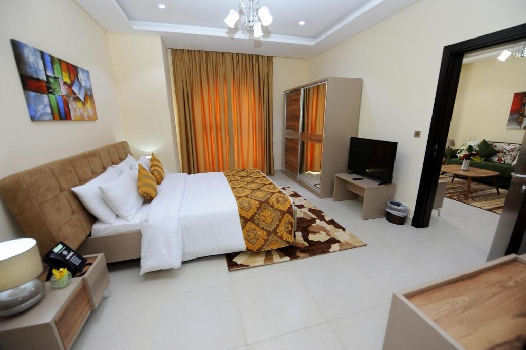 多哈Al Mansour Park Inn Hotel&Apartment的一间卧室设有一张床和一间客厅。