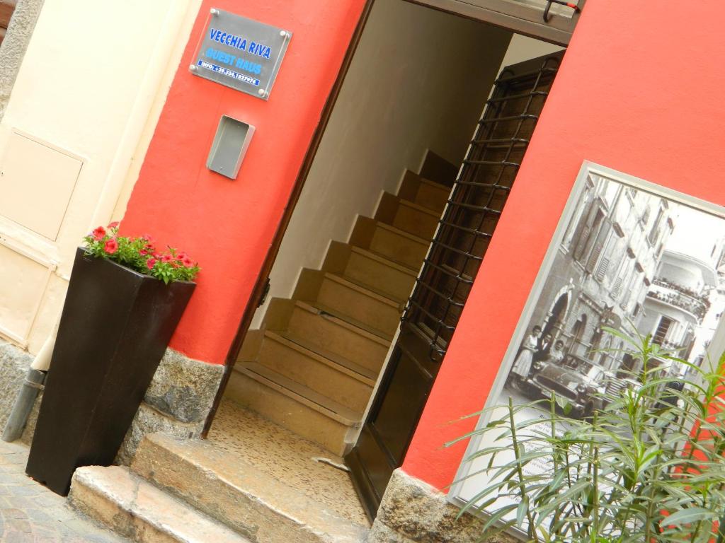 加尔达湖滨维查利瓦公寓式酒店的一座红色的建筑,上面有楼梯和标志