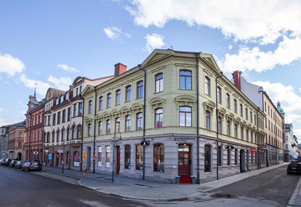 松兹瓦尔Sundsvall City Hotel的街道上一座大型建筑,前面有汽车停放