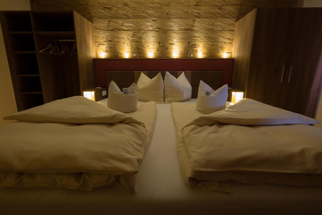 Gottsdorf祖姆朗格兰德酒店的一间卧室配有两张带枕头和灯的床。