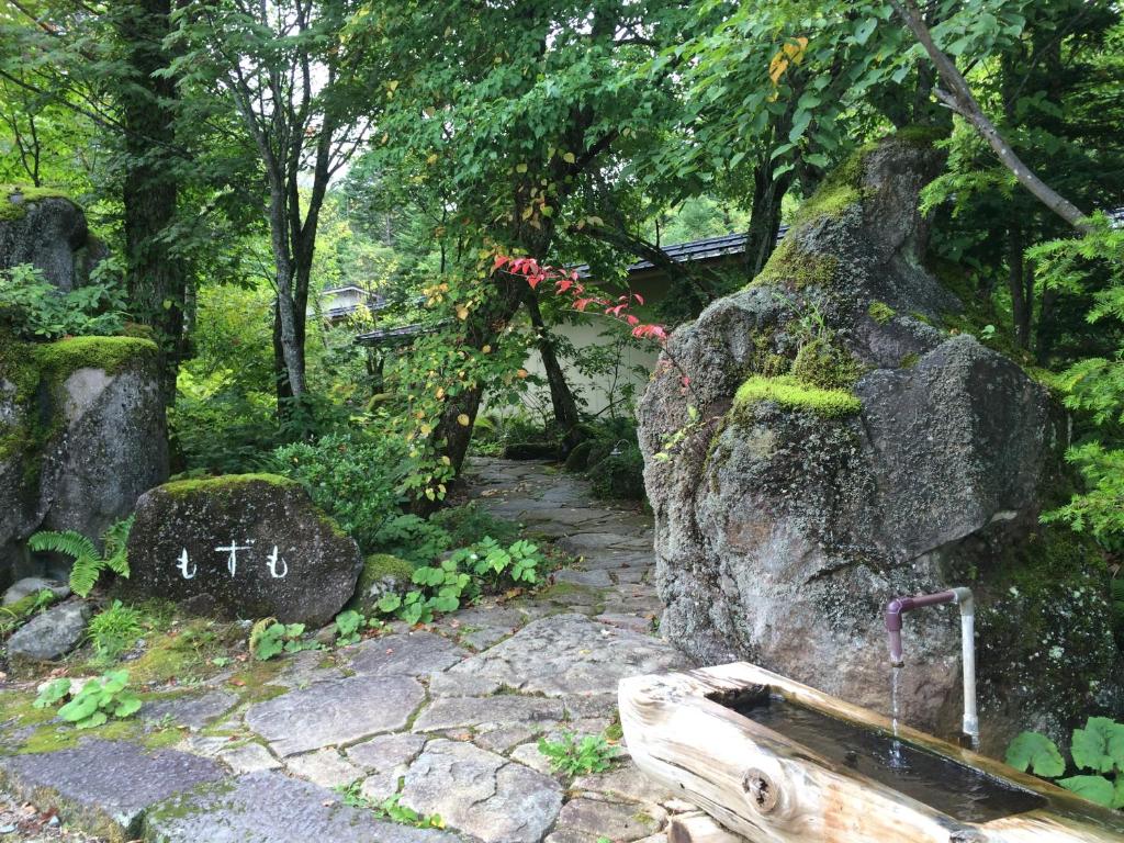 高山奥飞驒温泉乡旅馆（仅限成人入住）的一座花园,花园内设有石路和种有苔 ⁇ 的岩石