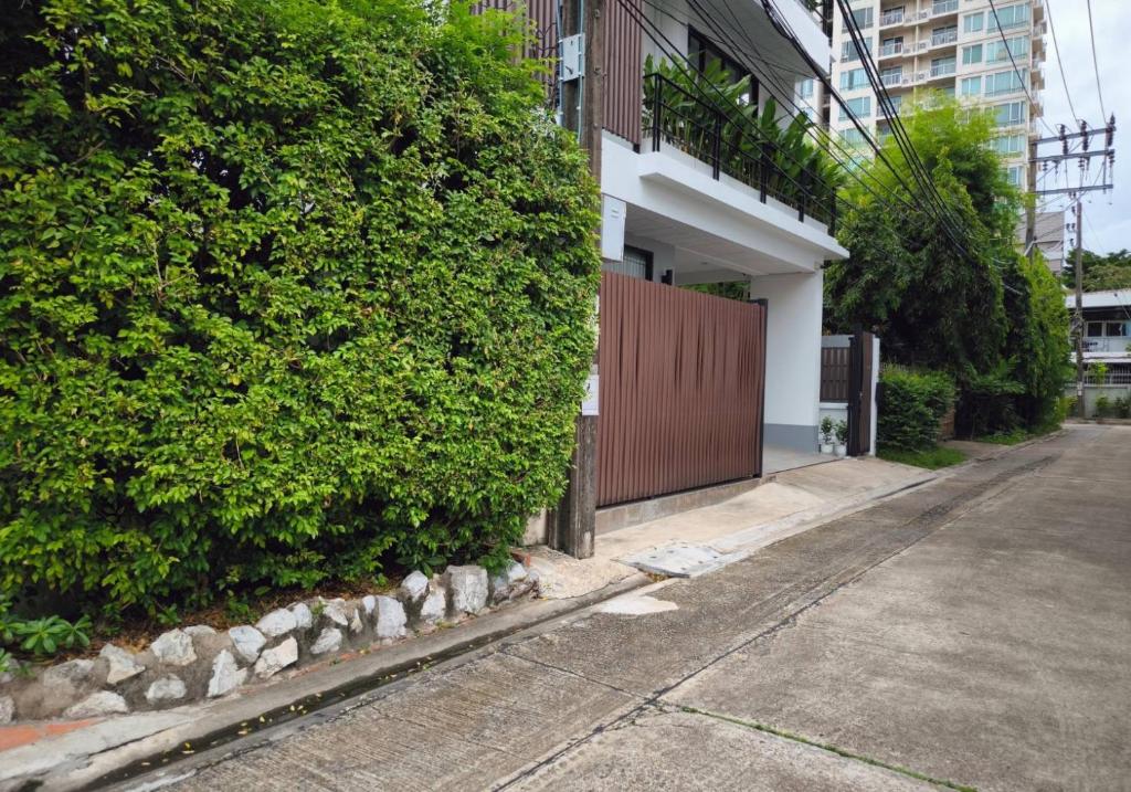 曼谷Studio Sukumvit 29的一条空的街道,旁边是带有树 ⁇ 的建筑