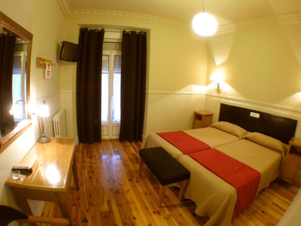 昆卡卡诺瓦斯旅馆的一间卧室配有一张床、一张桌子和一张书桌