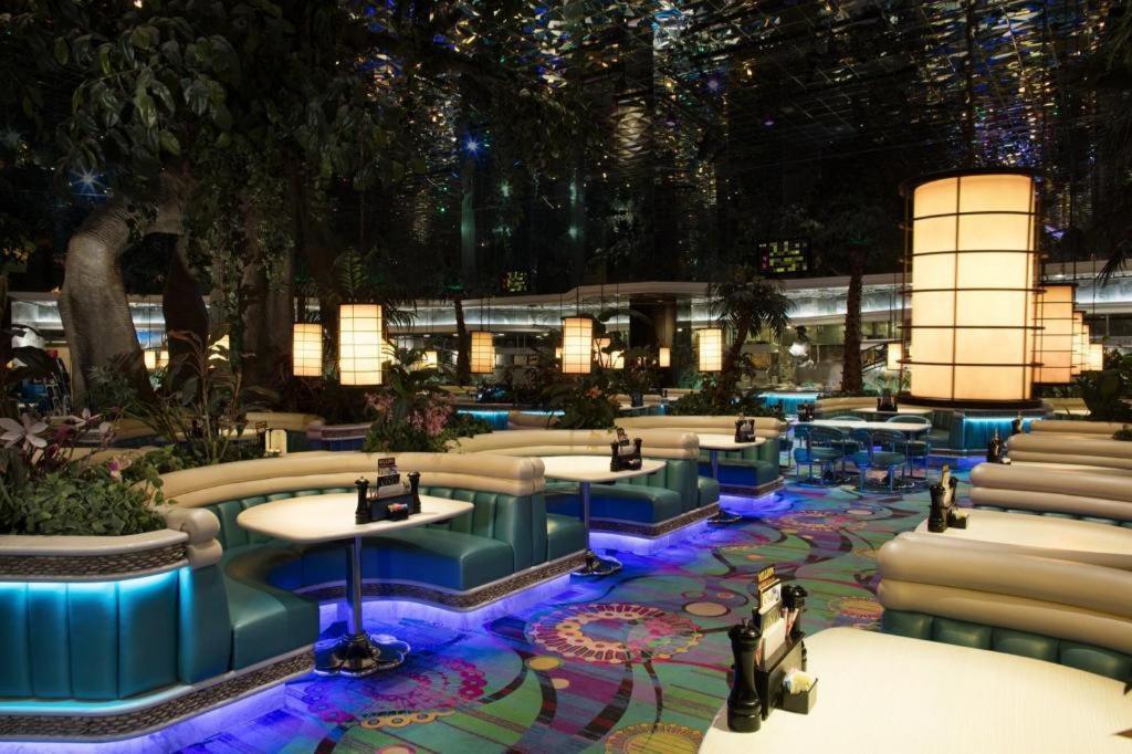 里诺Peppermill Resort Spa Casino的一个带桌椅的大堂和一座建筑