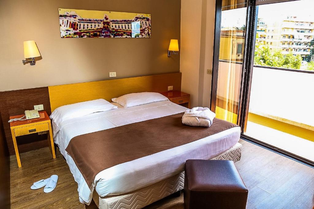 罗马西斯托弗酒店的一间卧室设有一张大床和一个大窗户