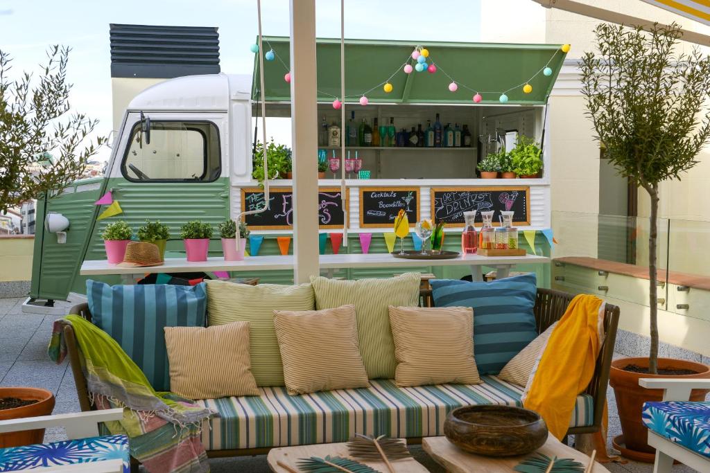 马德里敏特文奇酒店的一个带沙发和食品车的庭院