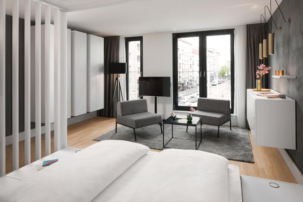 柏林AMANO HOME Apartments的卧室配有白色的床和2把椅子