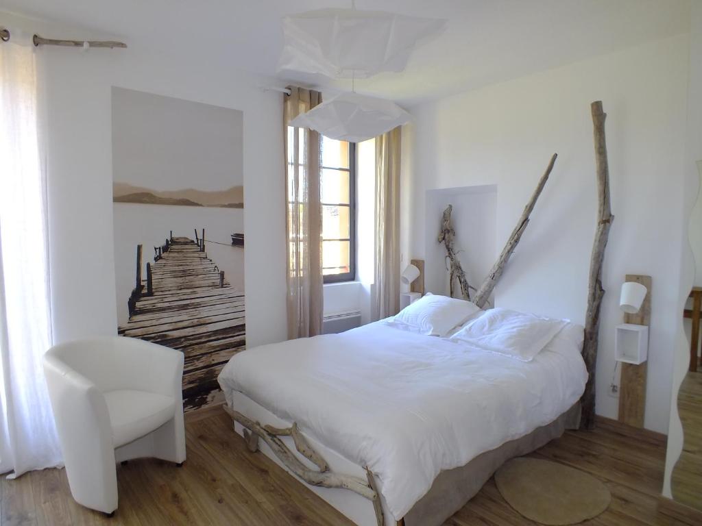 La TourLa Maison de la Tour的卧室配有白色的床和白色椅子