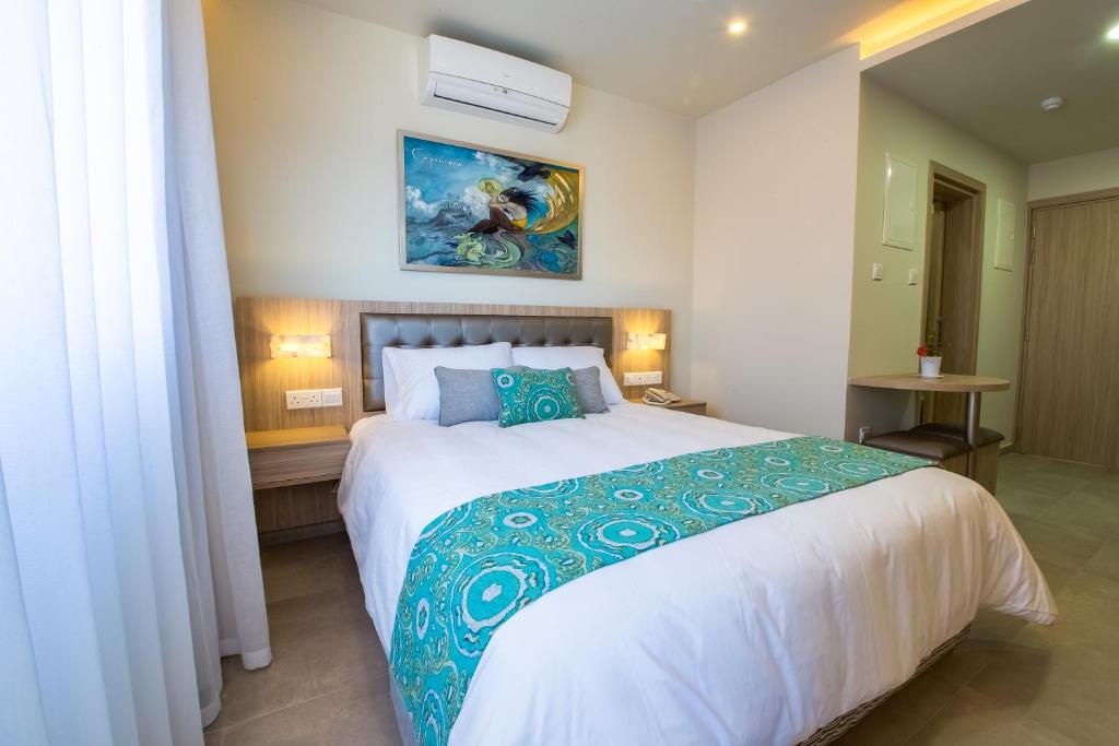拉纳卡十二宫公寓式酒店的一间卧室配有一张带蓝色和白色棉被的大床