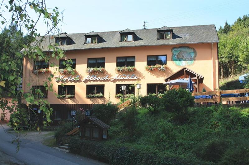 WasserlieschWaldhotel Albachmühle mit Albacher Stuben的一座大型建筑,窗户上布满了植物