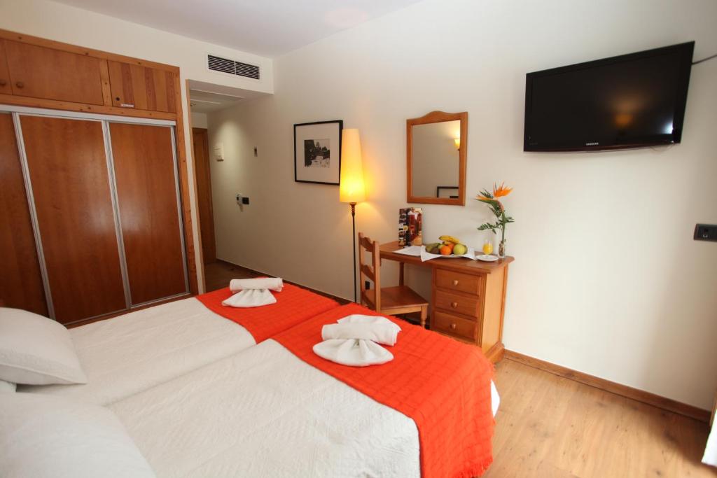 罗德里戈城酒庄酒店的一间卧室配有一张带红色毯子的大床