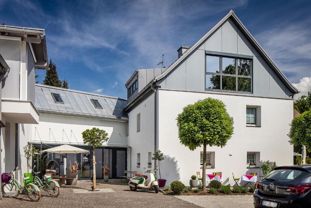 萨尔茨堡维尔德别墅住宿加早餐旅馆的停车场内有一辆小型摩托车停放的白色房子