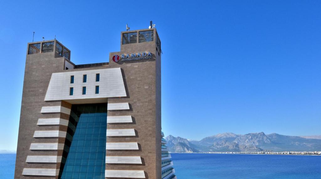 安塔利亚安塔利亚华美达广场酒店的一座有楼梯的建筑,通往水面