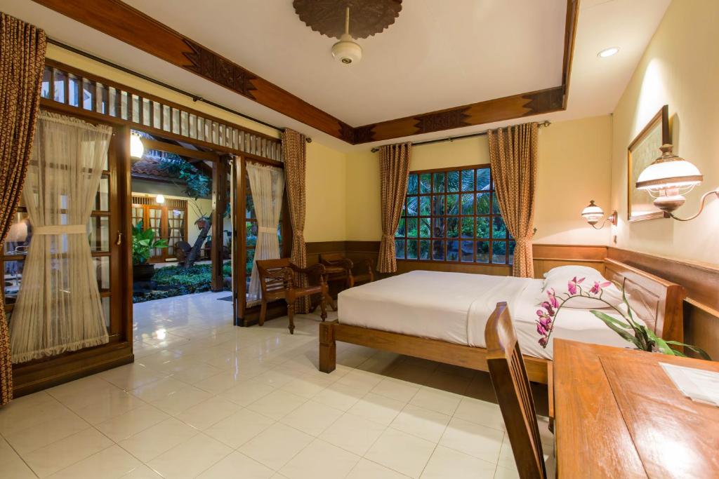 日惹杜达花园酒店的一间卧室设有一张床和一间用餐室