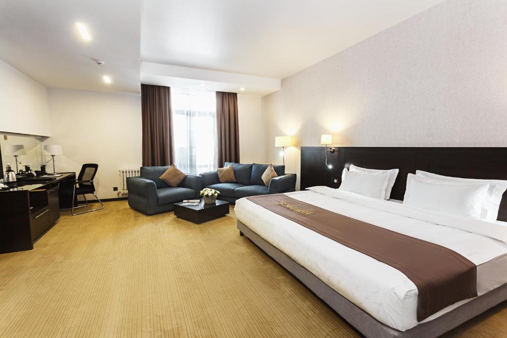 比什凯克梭路特酒店的酒店客房设有一张大床和一张沙发。