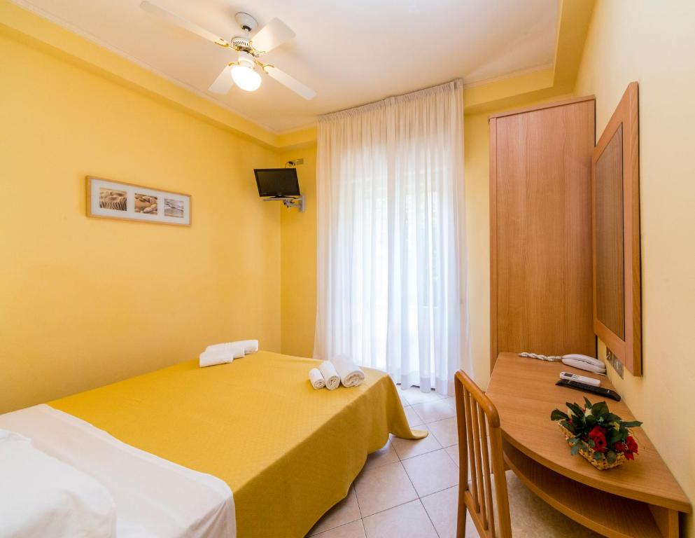 里乔内Hotel Rita的酒店客房设有两张床和一张桌子。