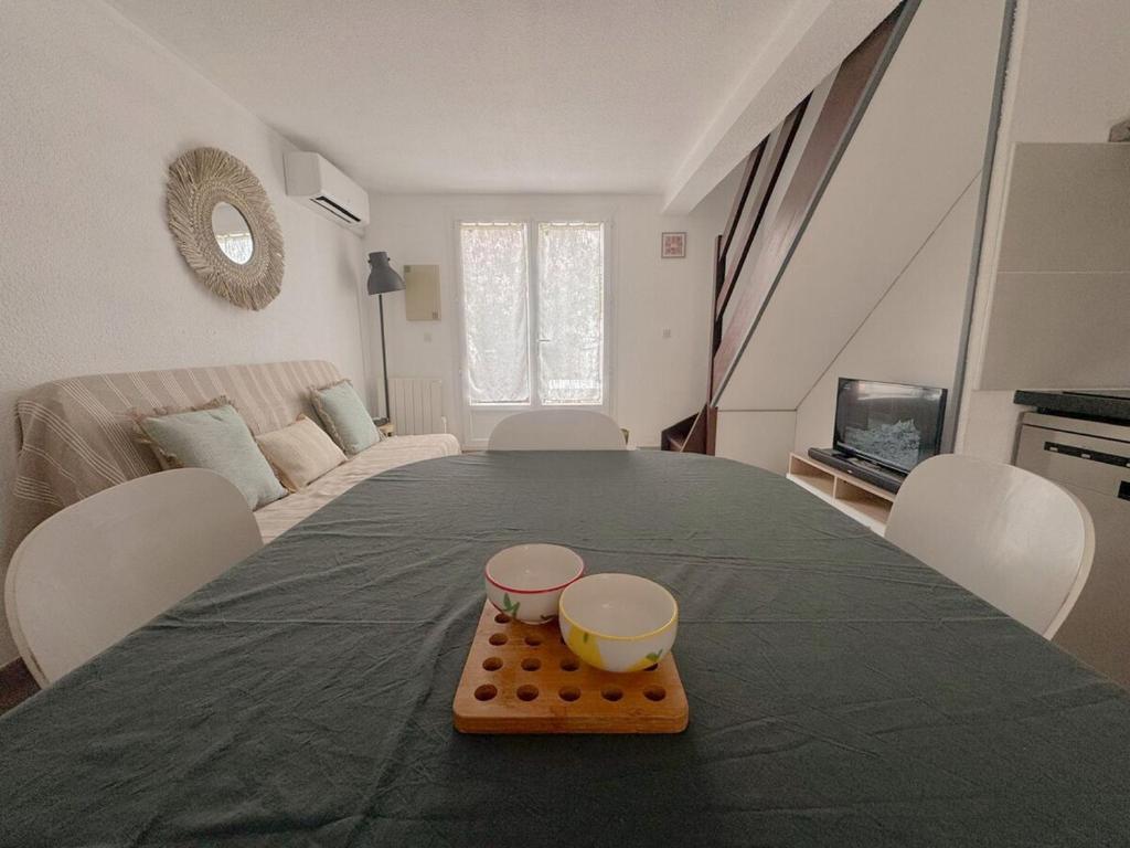乐巴凯尔斯Maison vacances proche de la mer的桌子上铺着绿色桌布，上面有两个碗