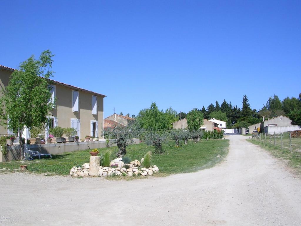 埃加利埃La Sarriette, Chambres d'hôtes et gîte d'étape à Eygalieres 13810的一条土路,有房子和院子