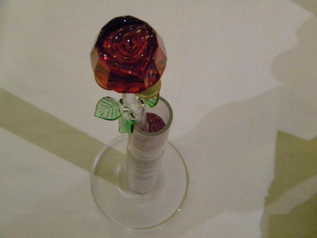 塞斯托拉Hotel del Corso的一张桌子上玻璃瓶里的红玫瑰