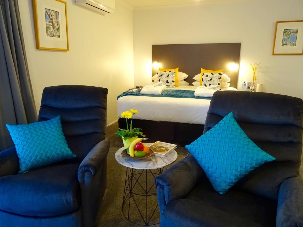 汉密尔顿BKs Premier Motel Hamilton的酒店客房带两把椅子和一张床