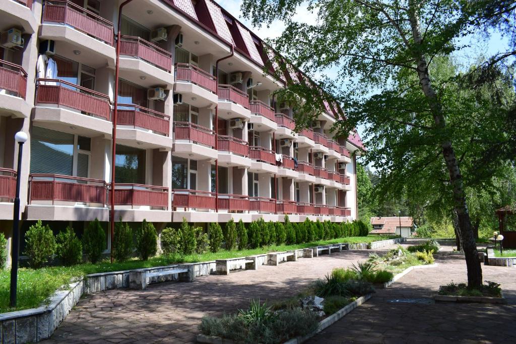 科斯泰内茨Constantzia Balneohotel的公寓大楼设有红色的阳台和庭院。
