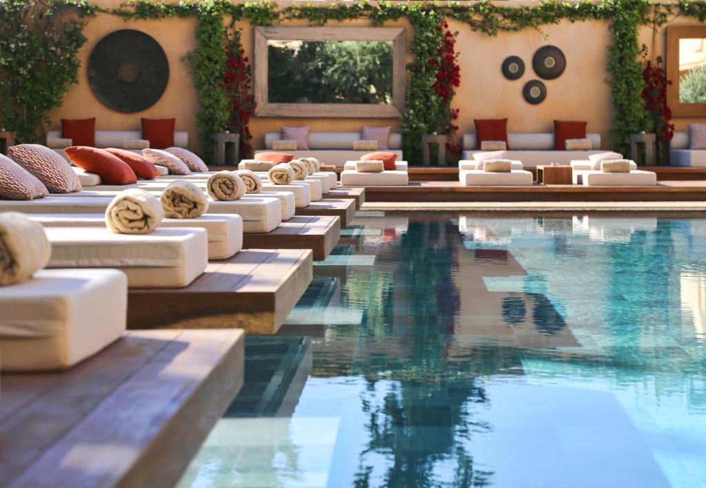 雅典玛吉酒店的酒店游泳池设有白色躺椅和游泳池
