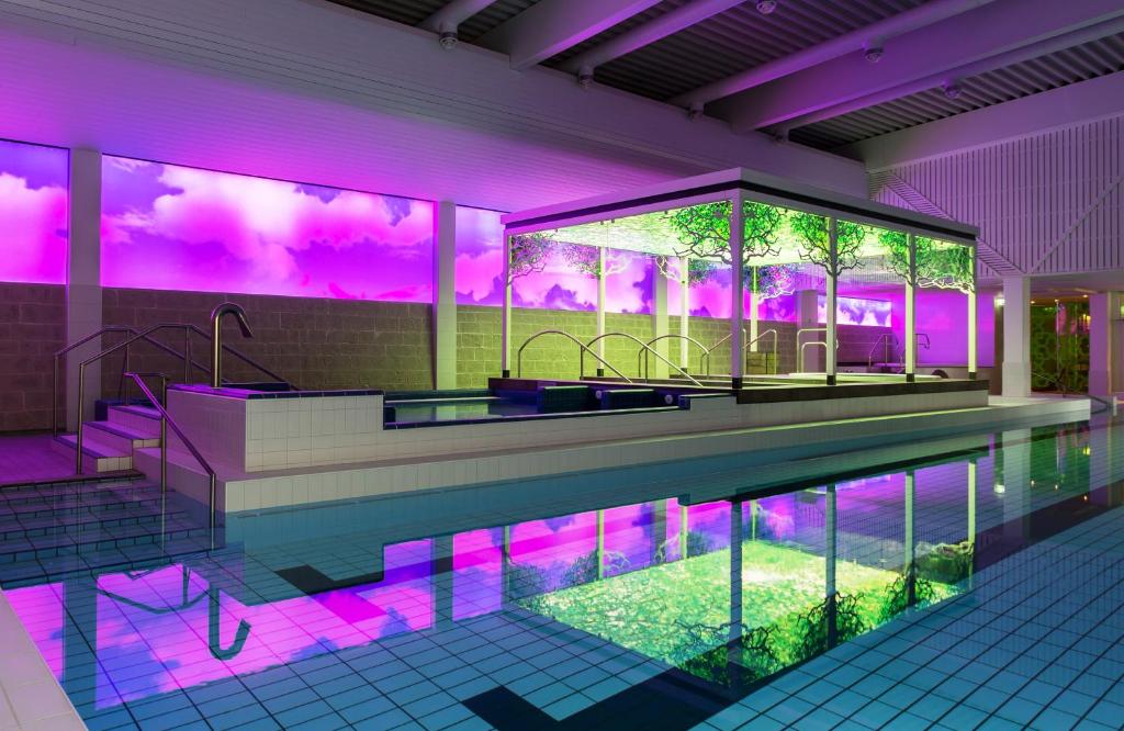 KarjalohjaLohja Spa & Resort的一座带紫色照明的游泳池的房子