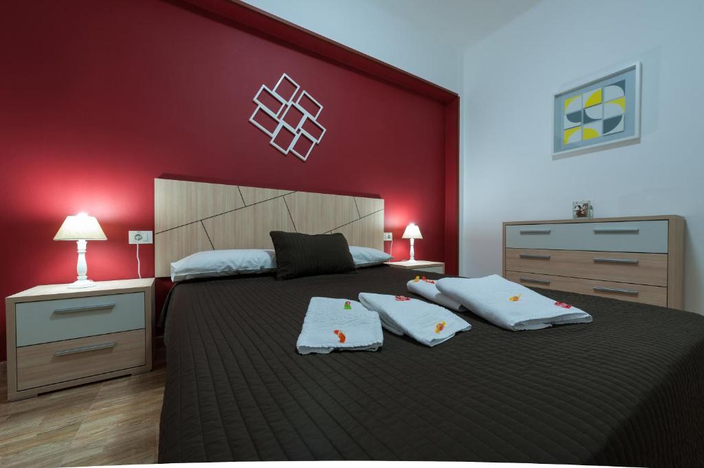 大加那利岛拉斯帕尔马斯Apartamentos Vacacionales Las Palmas Urban Center的一间卧室设有一张红色墙壁的大床