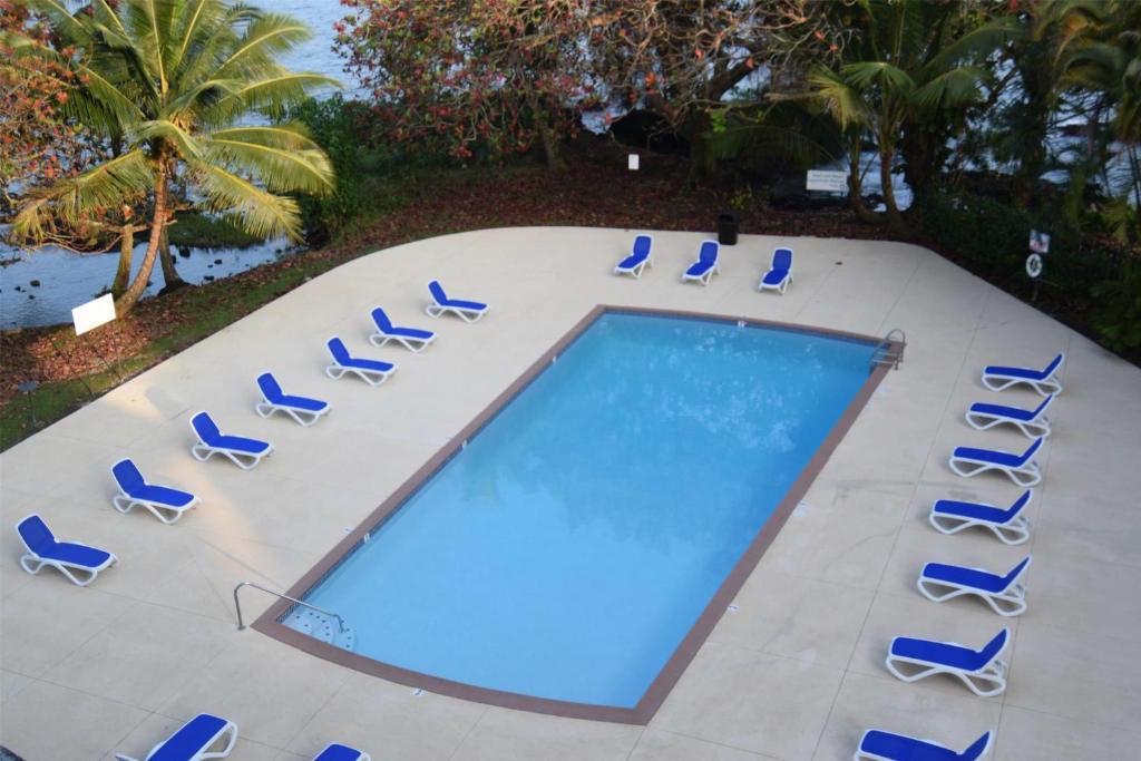 希洛Hilo Hawaiian Hotel, Trademark Collection by Wyndham的享有带躺椅的游泳池和游泳池的顶部景致