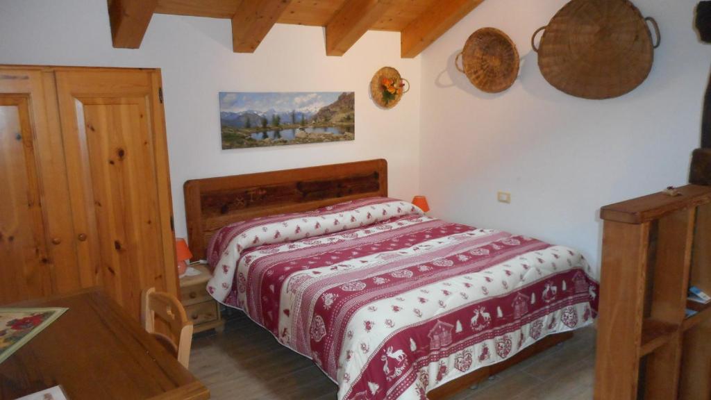 Saint-ChristopheLa Luge的一间卧室配有一张带红白毯子的床